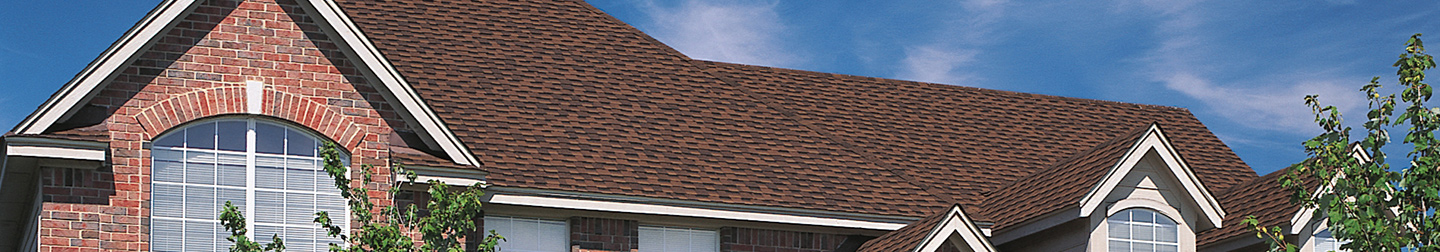 Brick house with shingles on roof